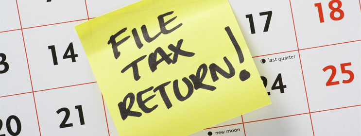 calendar image with post-it note and handwritten reminder to file tax return