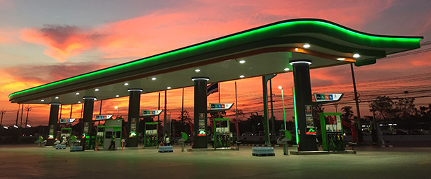 image of gas pumps outside of convenience store at night