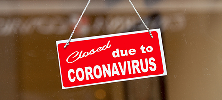 sign on store window reading closed due to coronavirus