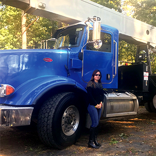 Photo of Myriam Sanchez in front of blue crane